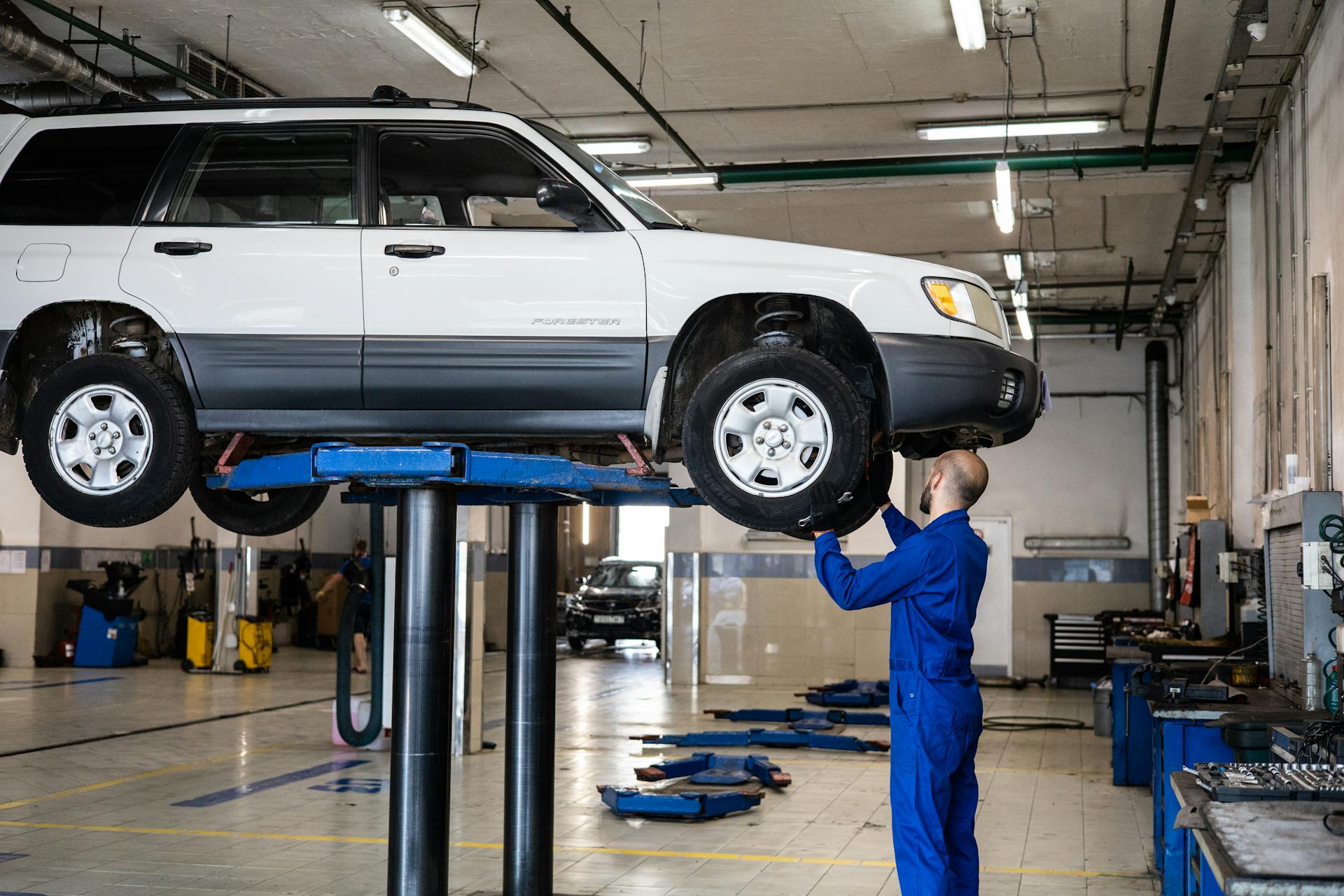 Mechanic inspecting vehicle on lift for pre-purchase inspection at Pro Automotive Repair