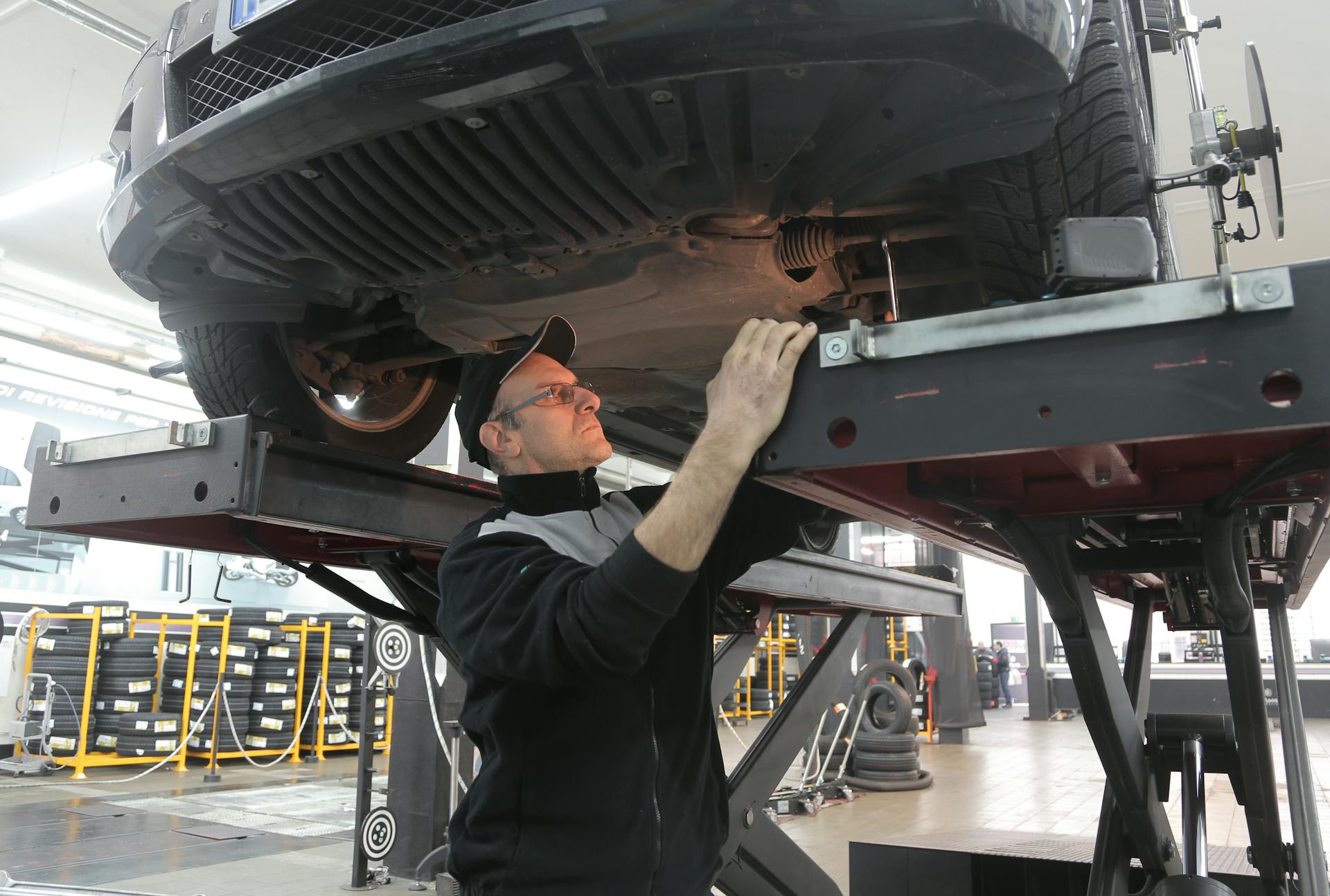 Mechanic inspecting vehicle undercarriage during service at Pro Automotive Repair